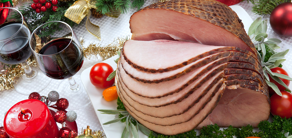 Holiday ham dinner, sliced ham with red wine on a table